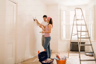 a man and a woman painting a room together
