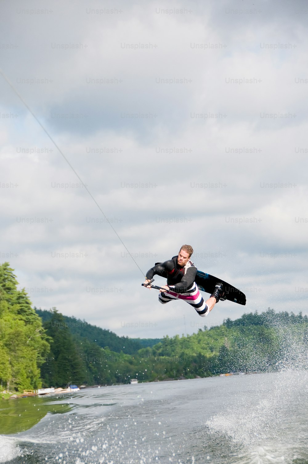 Un uomo che vola nell'aria mentre cavalca una tavola da kitesurf