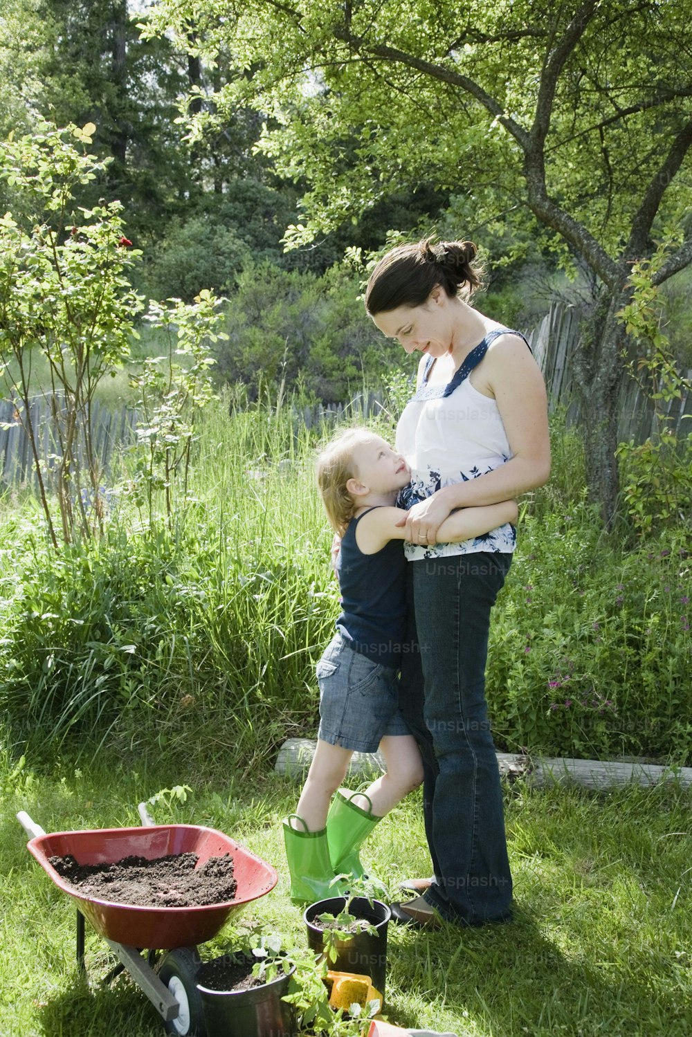 Una mujer sosteniendo a un niño en un jardín