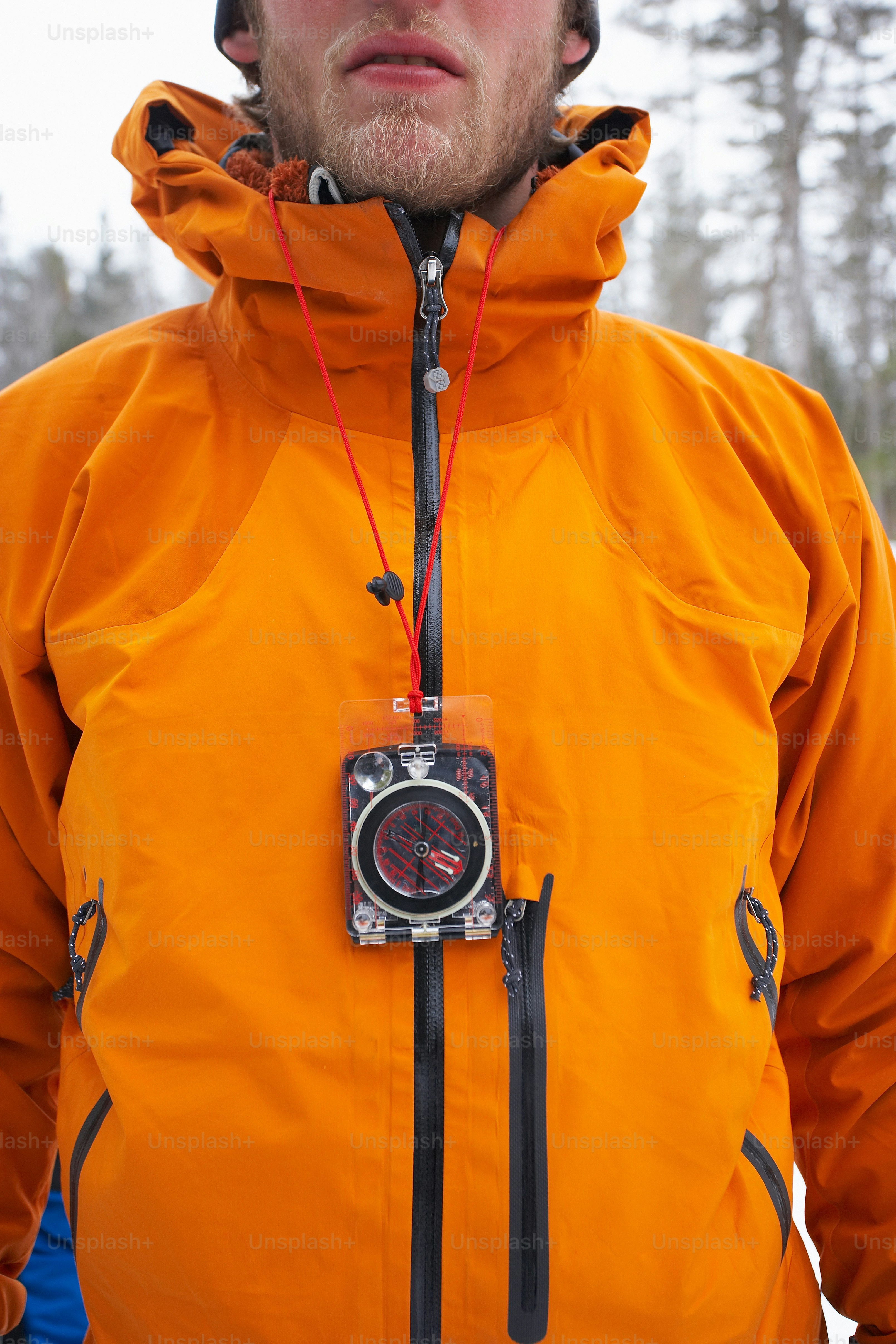 a man in an orange jacket with a camera attached to his jacket