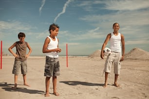 Un gruppo di giovani in piedi sulla cima di una spiaggia sabbiosa