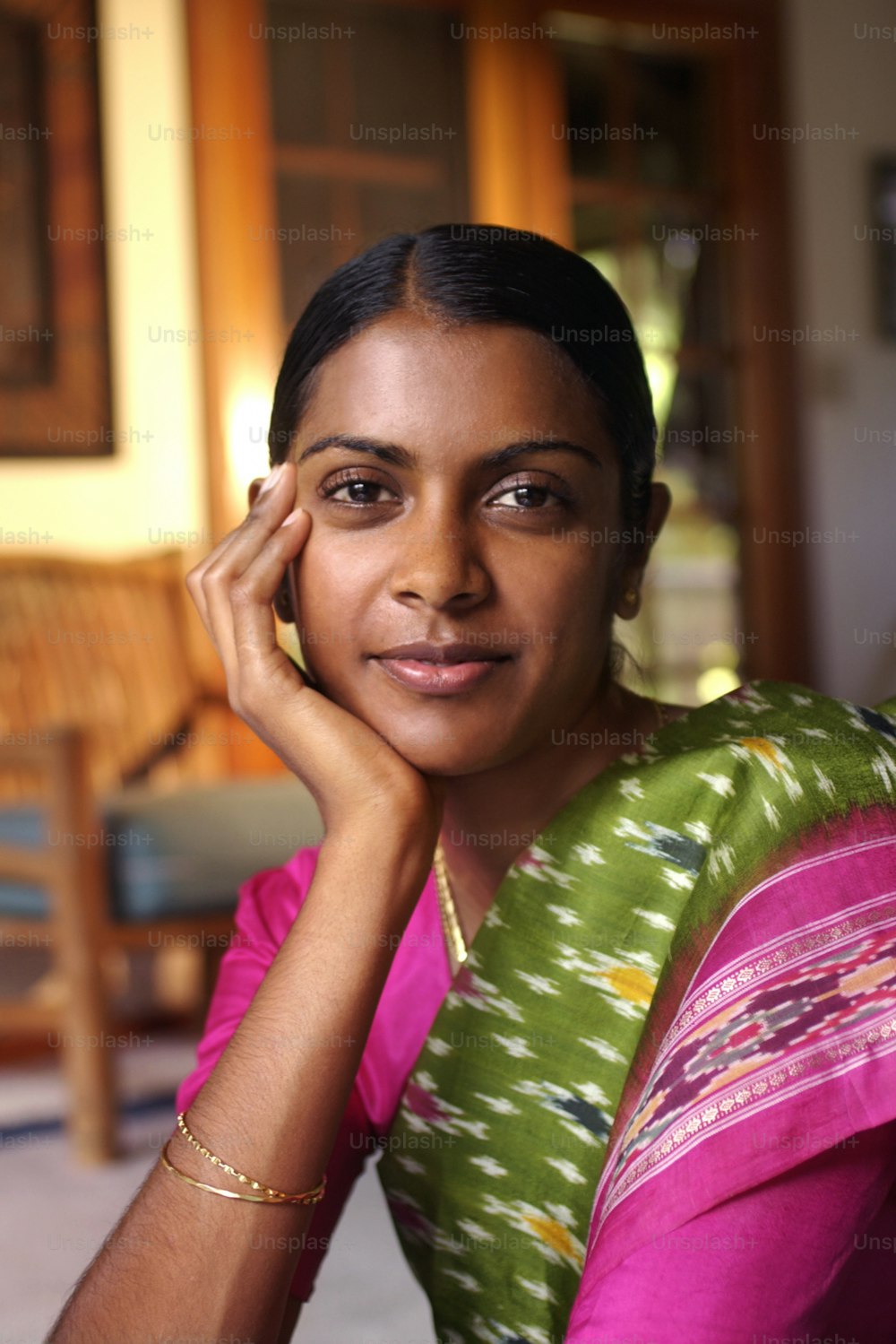 a woman in a green and pink sari posing for a picture