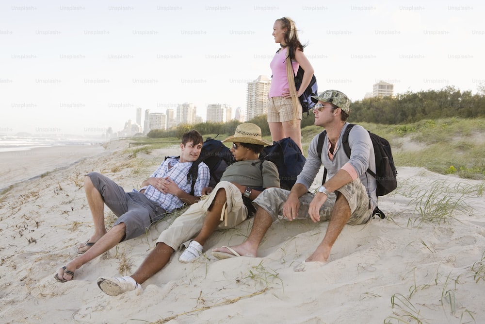Un gruppo di persone sedute sulla cima di una spiaggia sabbiosa