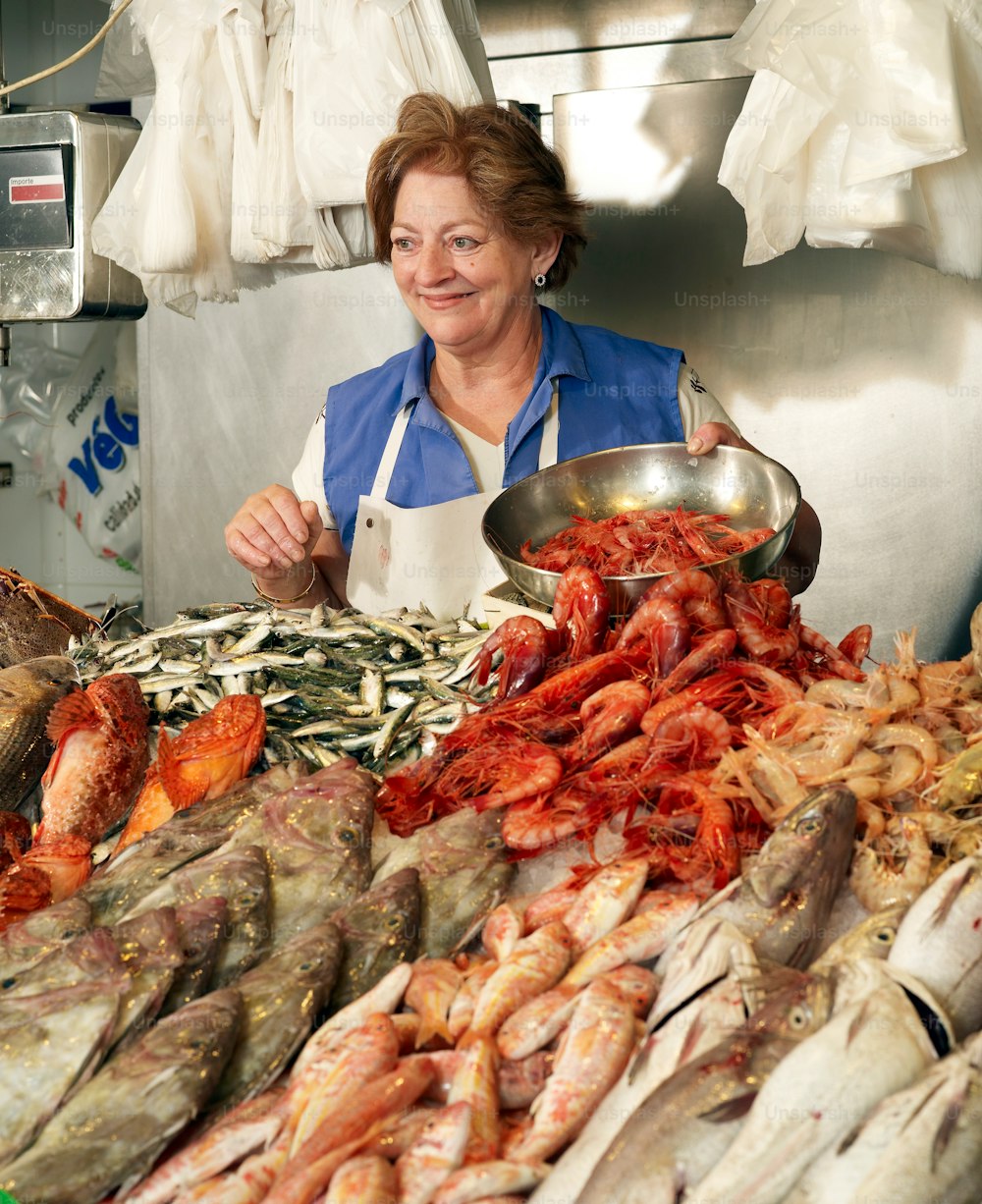 a woman standing in front of a pile of seafood