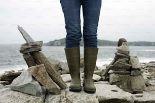 a person standing on rocks near the ocean