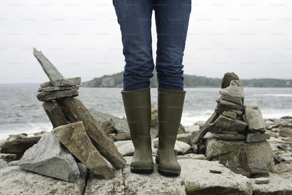 a person standing on rocks near the ocean