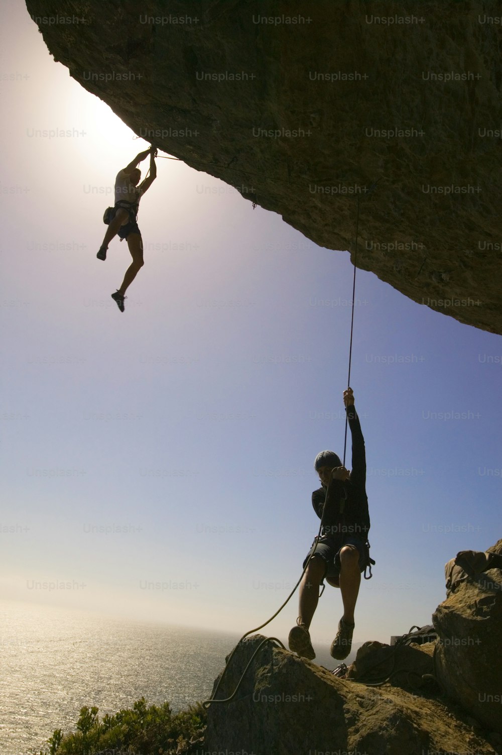a man on a rock climbing up a cliff