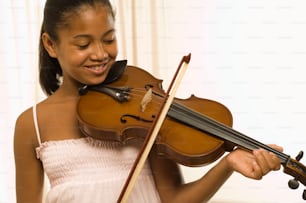 una ragazza in un vestito bianco che tiene un violino