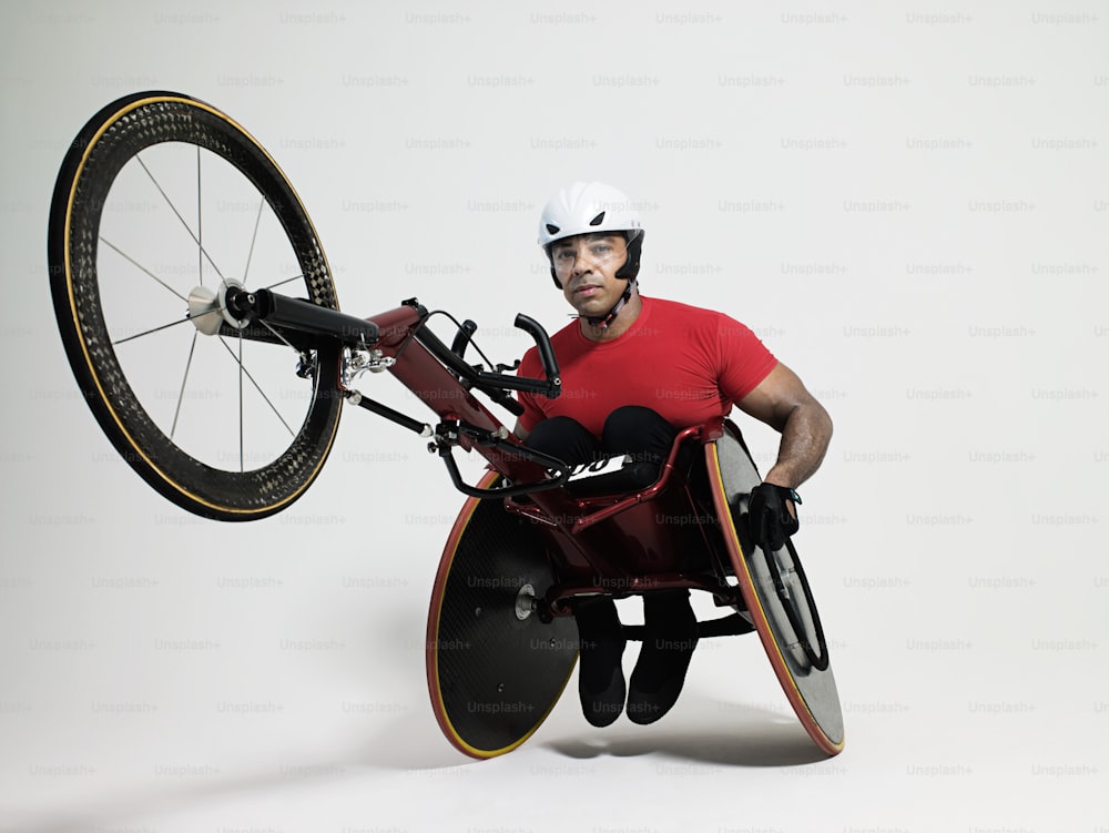 um homem em uma cadeira de rodas segurando uma bicicleta