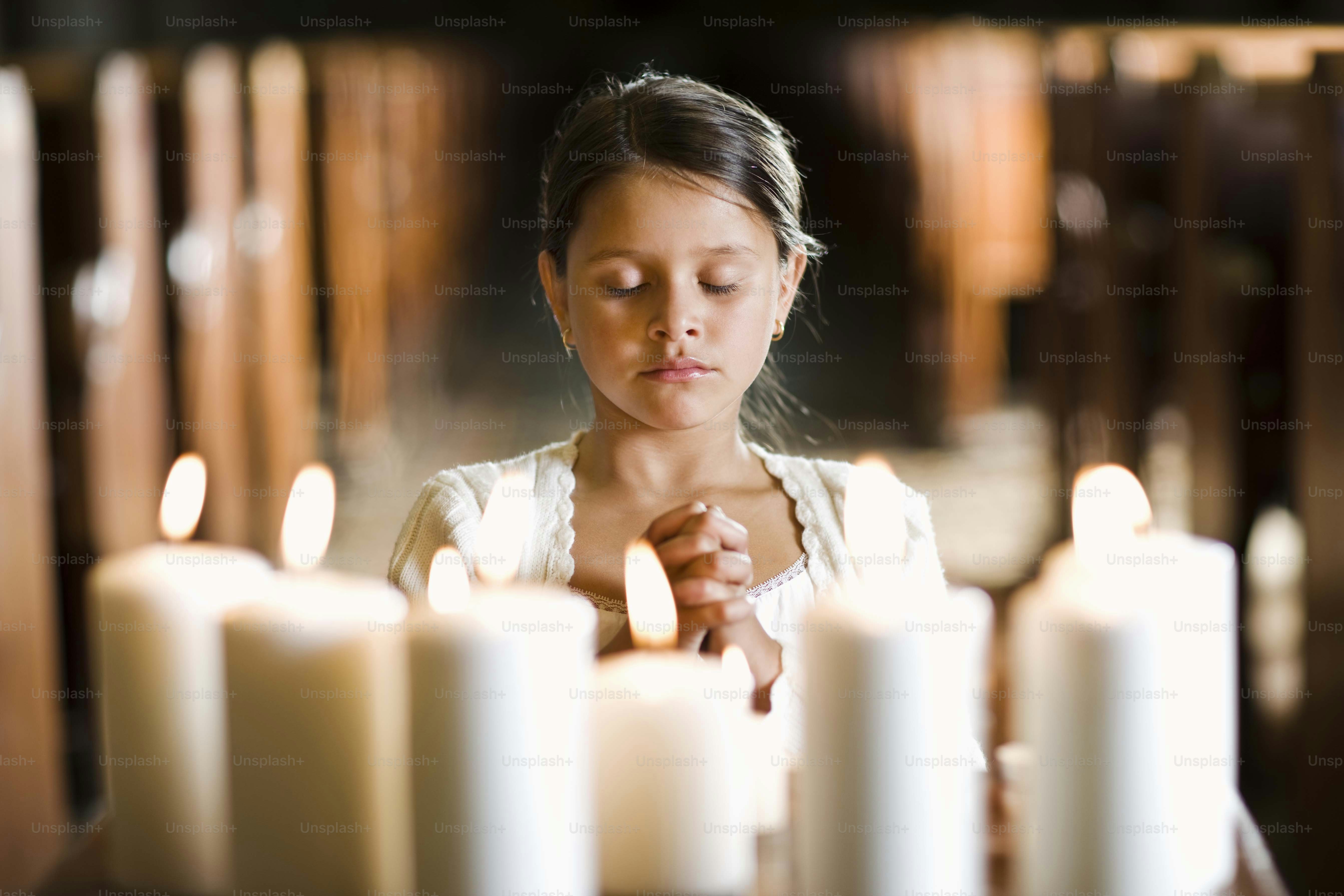 a young girl lighting candles in a church