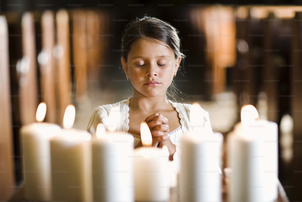 a young girl lighting candles in a church