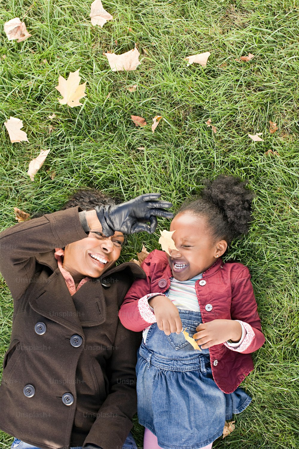 a woman and a child laying in the grass