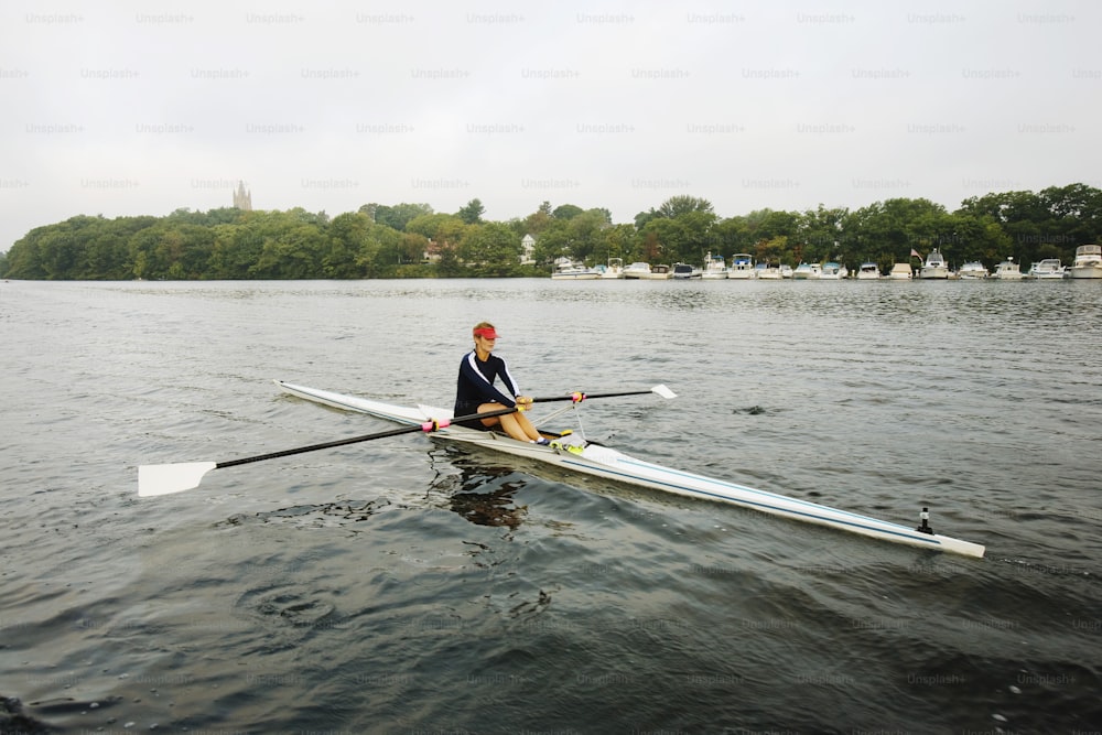 um homem sentado em cima de um barco na água