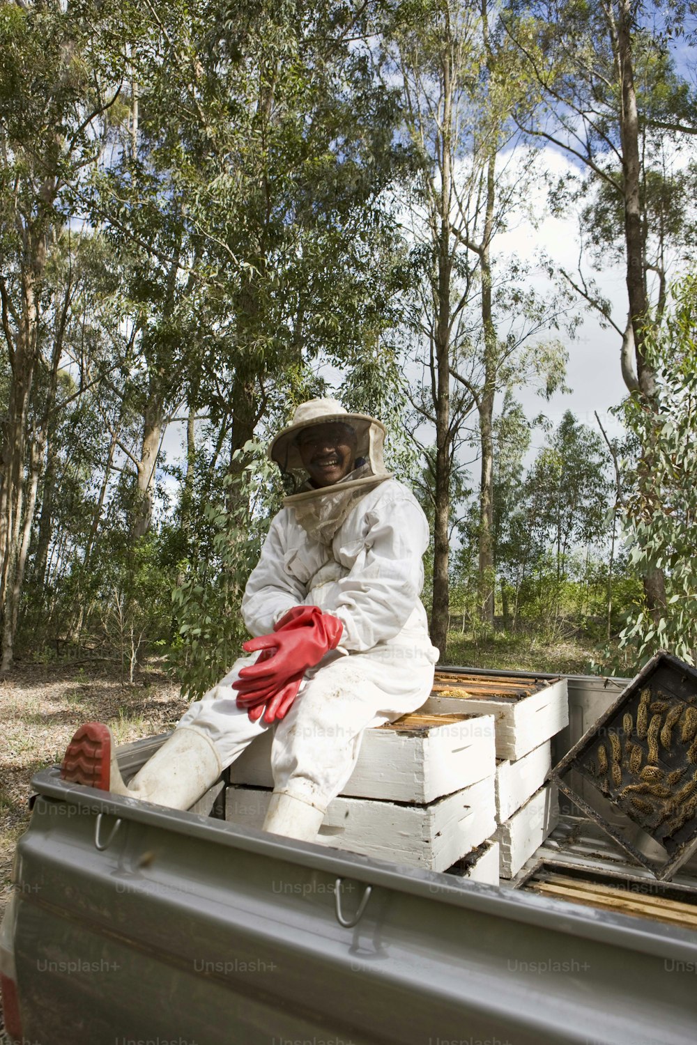 a beekeeper sitting in the back of a pick up truck