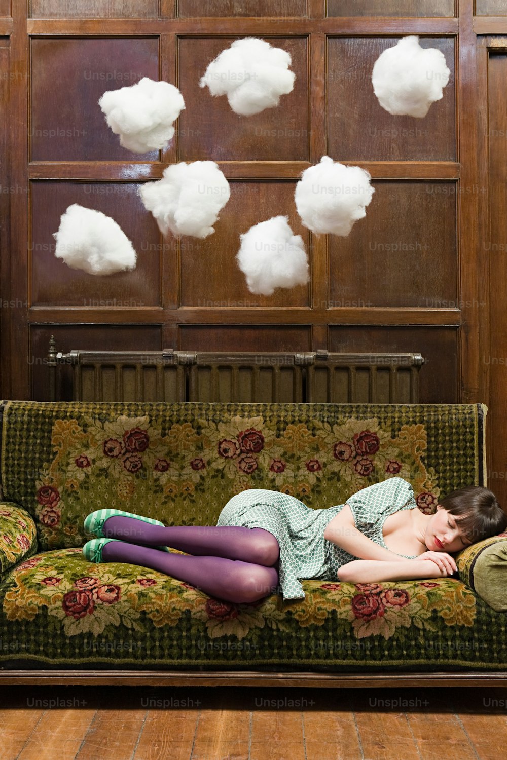 a woman laying on top of a green couch