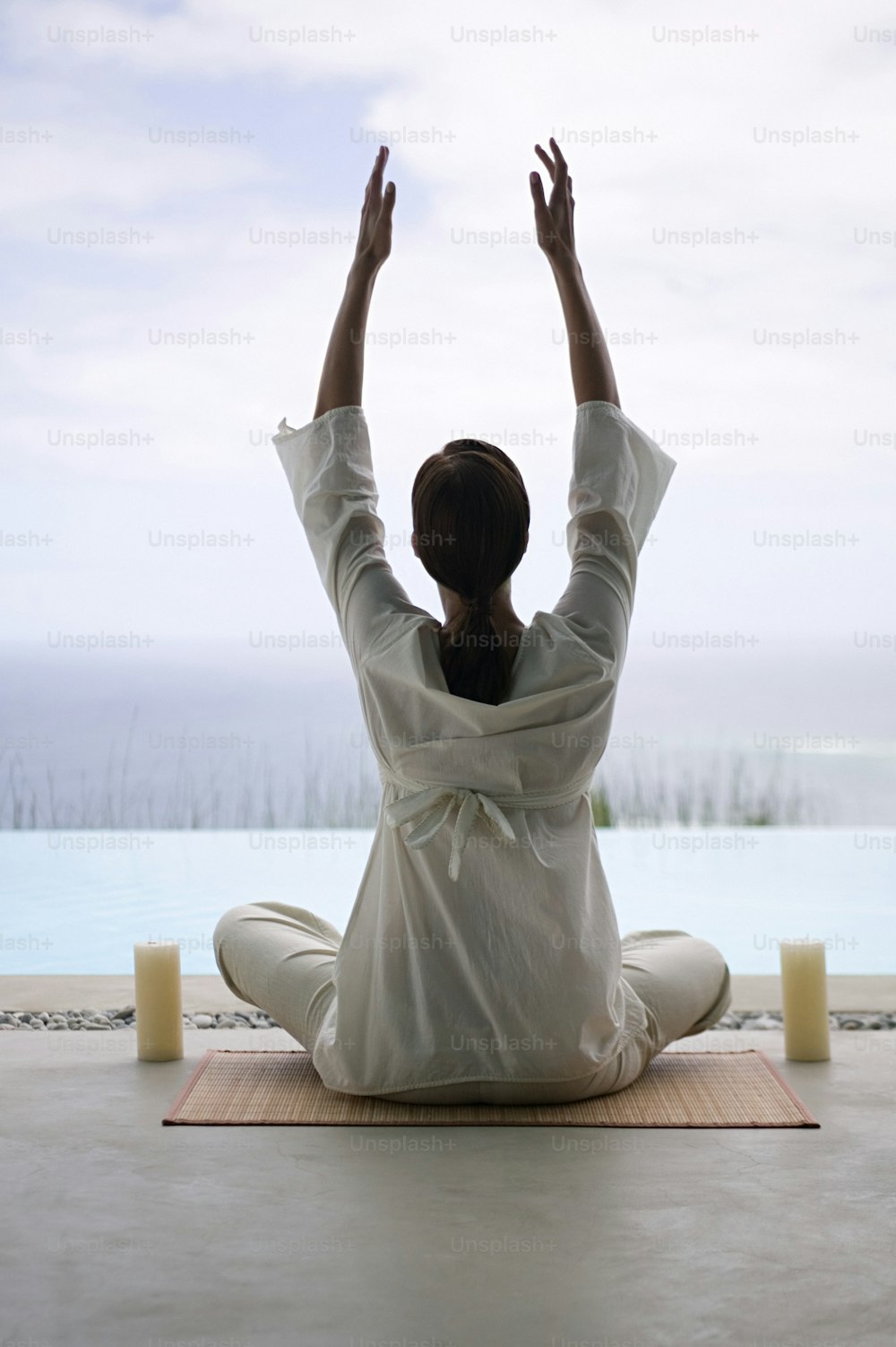 Una donna seduta su una stuoia che fa yoga