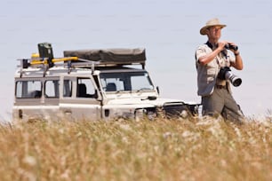 a man standing in a field with a camera