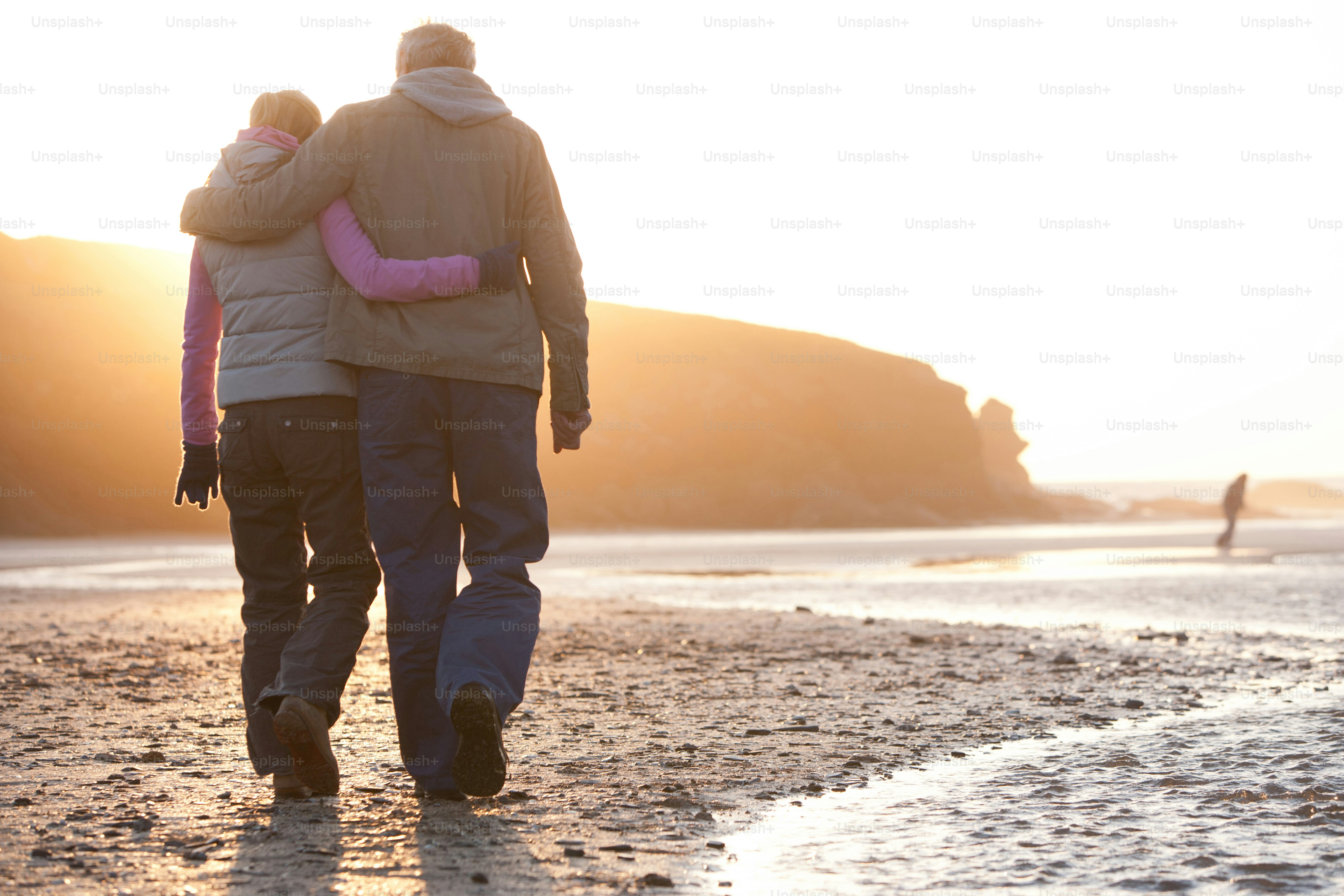 A man and a woman walking on a beach photo – Relaxation Image on Unsplash