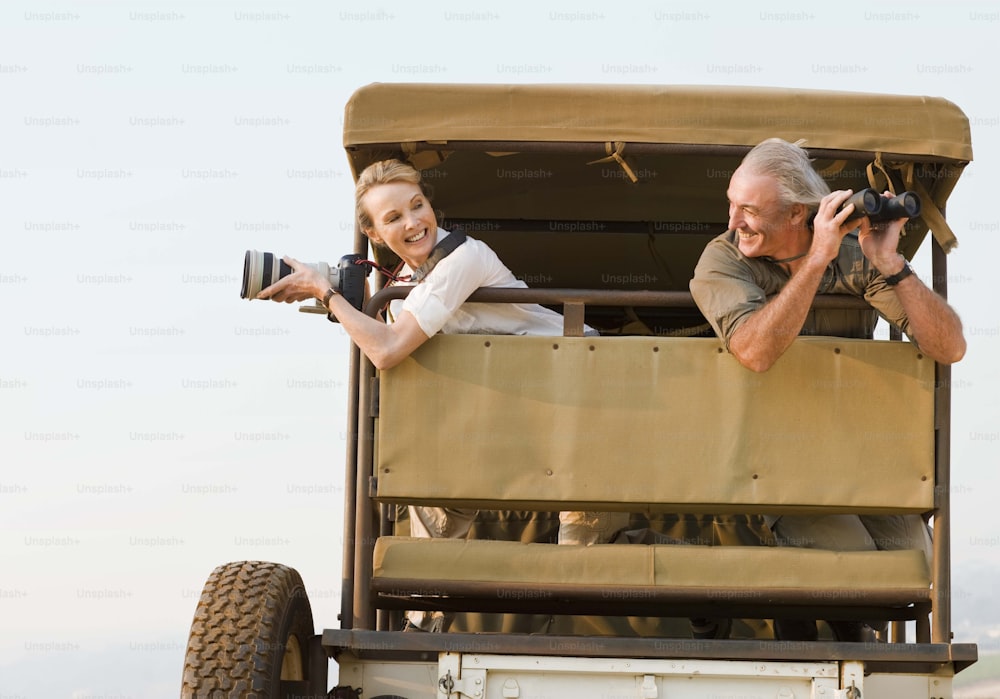 a man and a woman taking pictures in the back of a truck