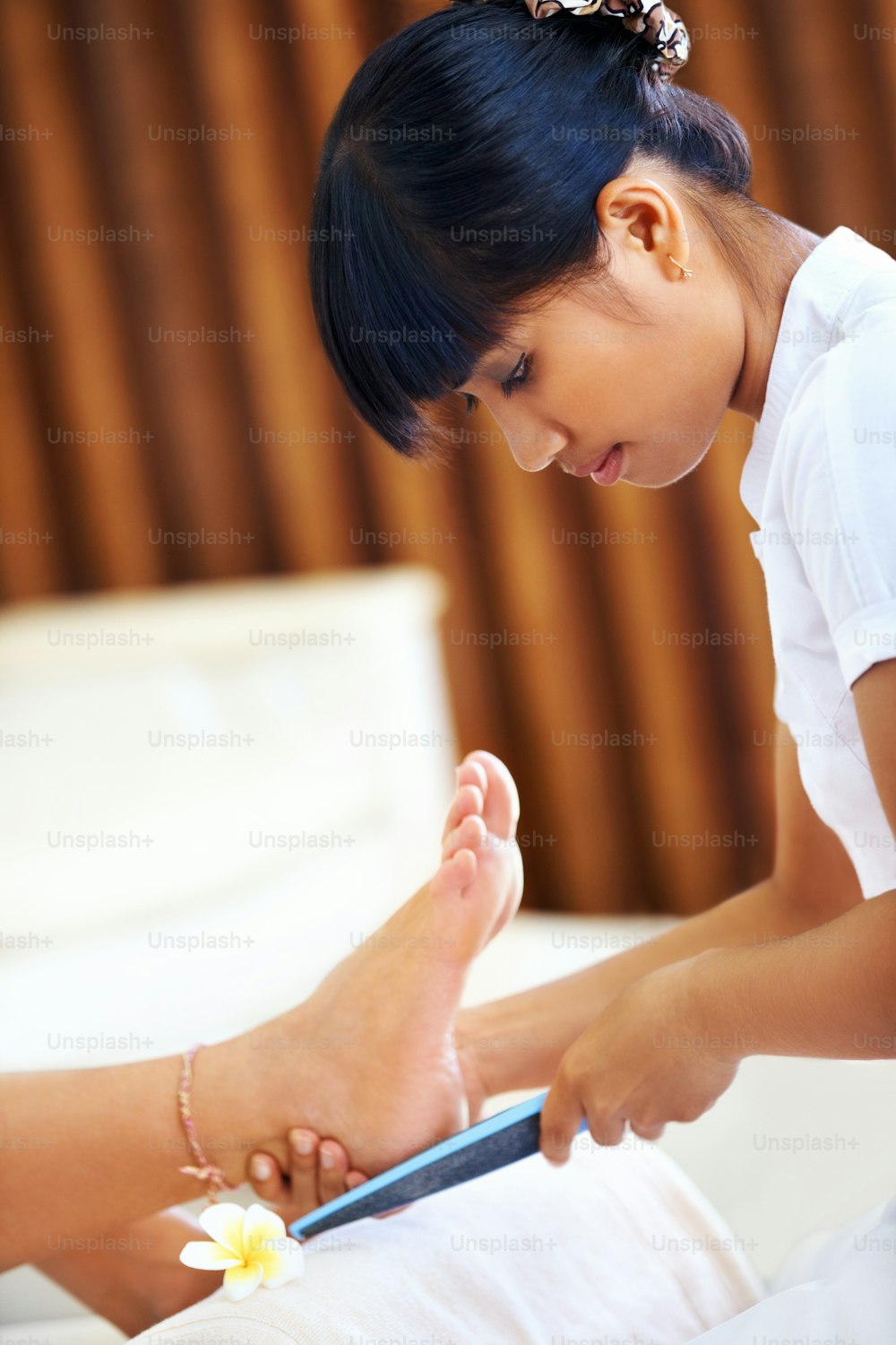 Pretty young girl gives a relaxing pedicure at a spa