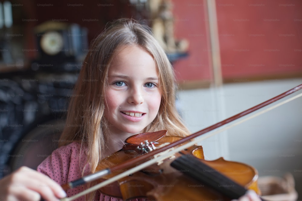 a young girl holding a violin in her hands