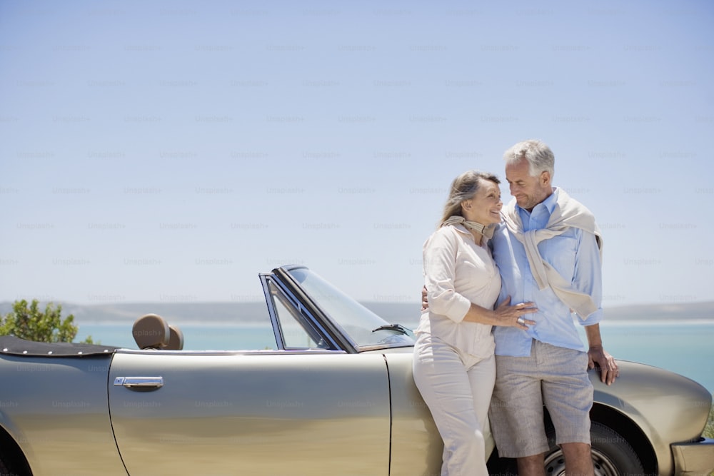 a man and a woman standing next to a car