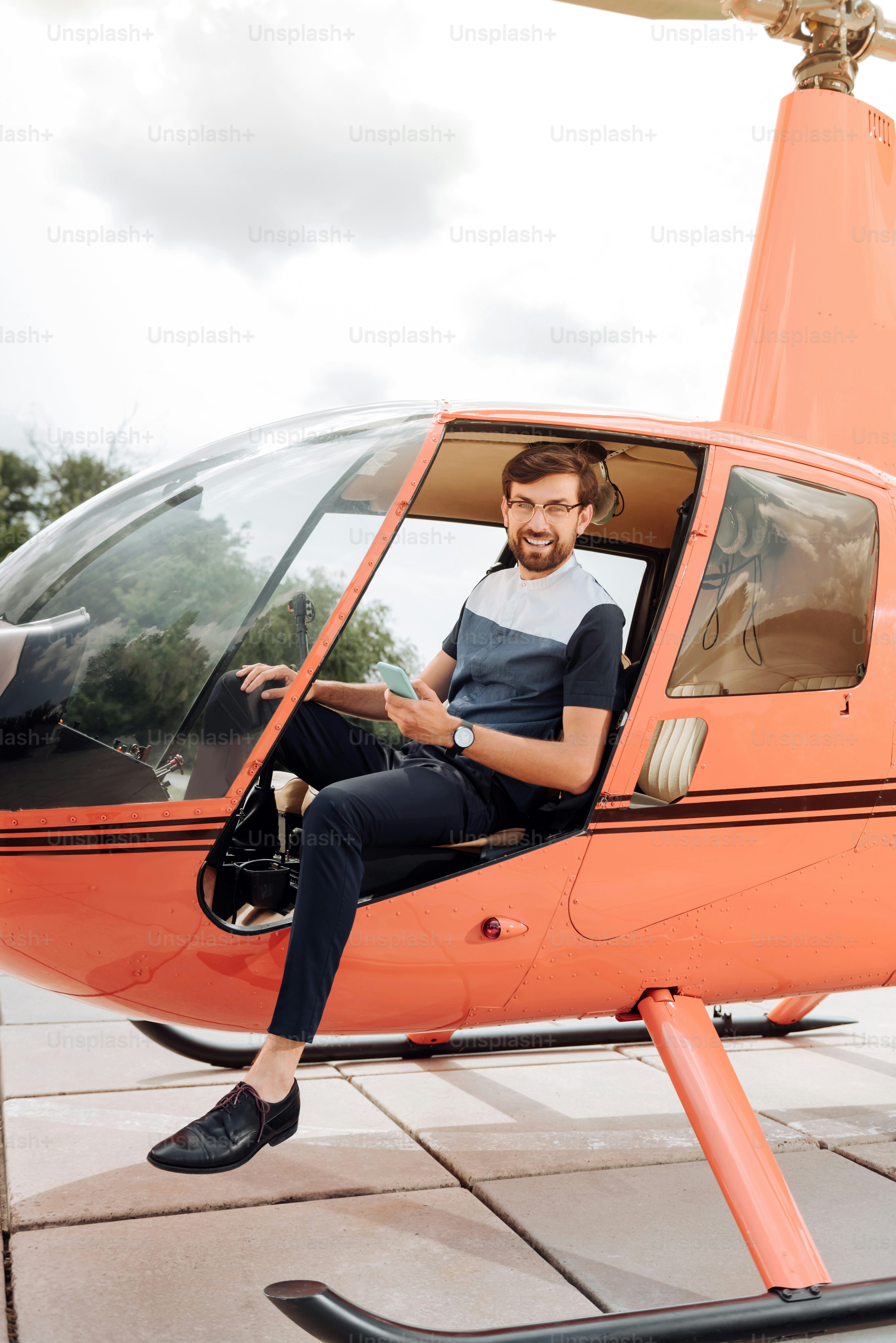 Quickly and comfortable. Energetic jolly man gazing at camera and waiting in helicopter