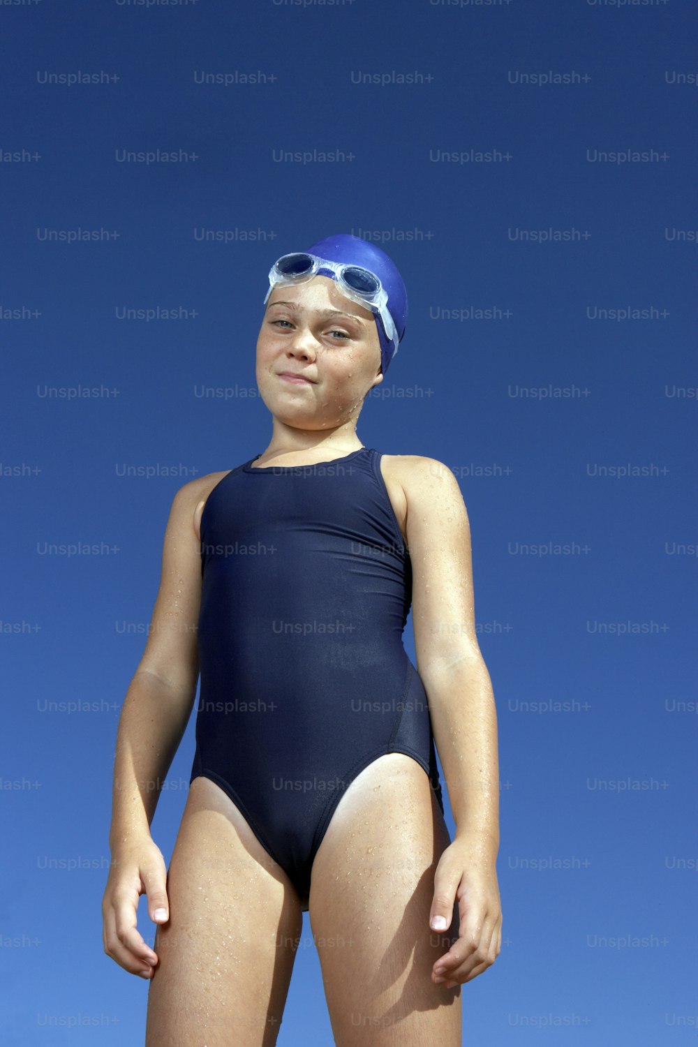 a young boy wearing a swimsuit and goggles