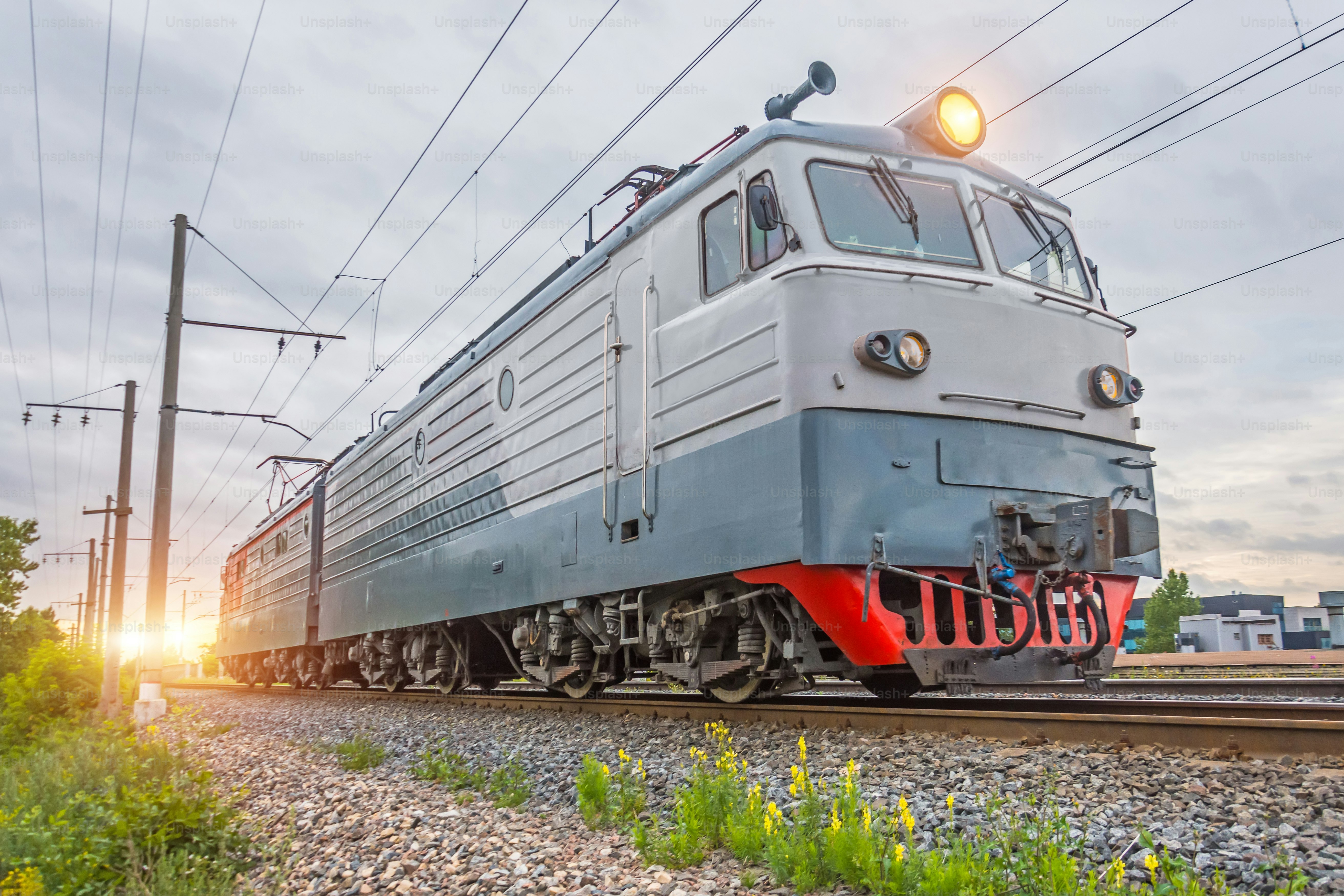 Single electric locomotive on the railway in the evening at sunset