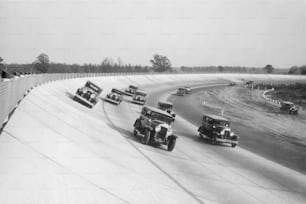 um grupo de carros dirigindo por uma pista de corrida