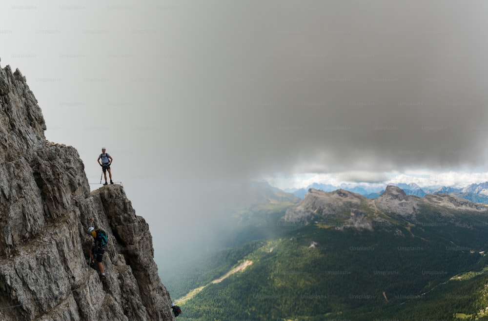 deux jeunes alpinistes masculins attrayants sur une Via Ferrata très exposée à Alta Badia dans les Dolomites italiennes