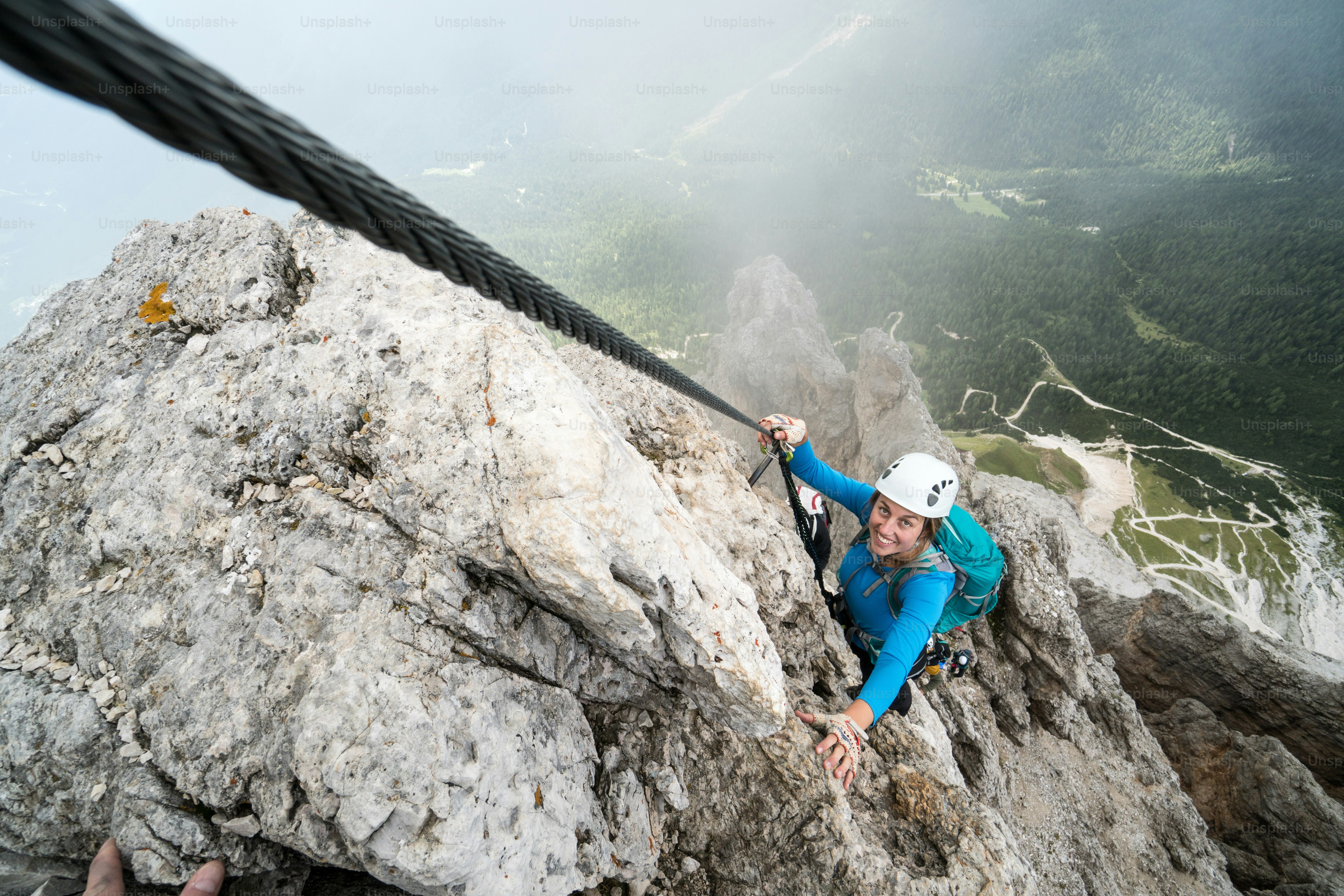 joven y atractiva alpinista en una empinada y expuesta vía ferrata en Alta Badia en el Tirol del Sur en los Dolomitas italianos