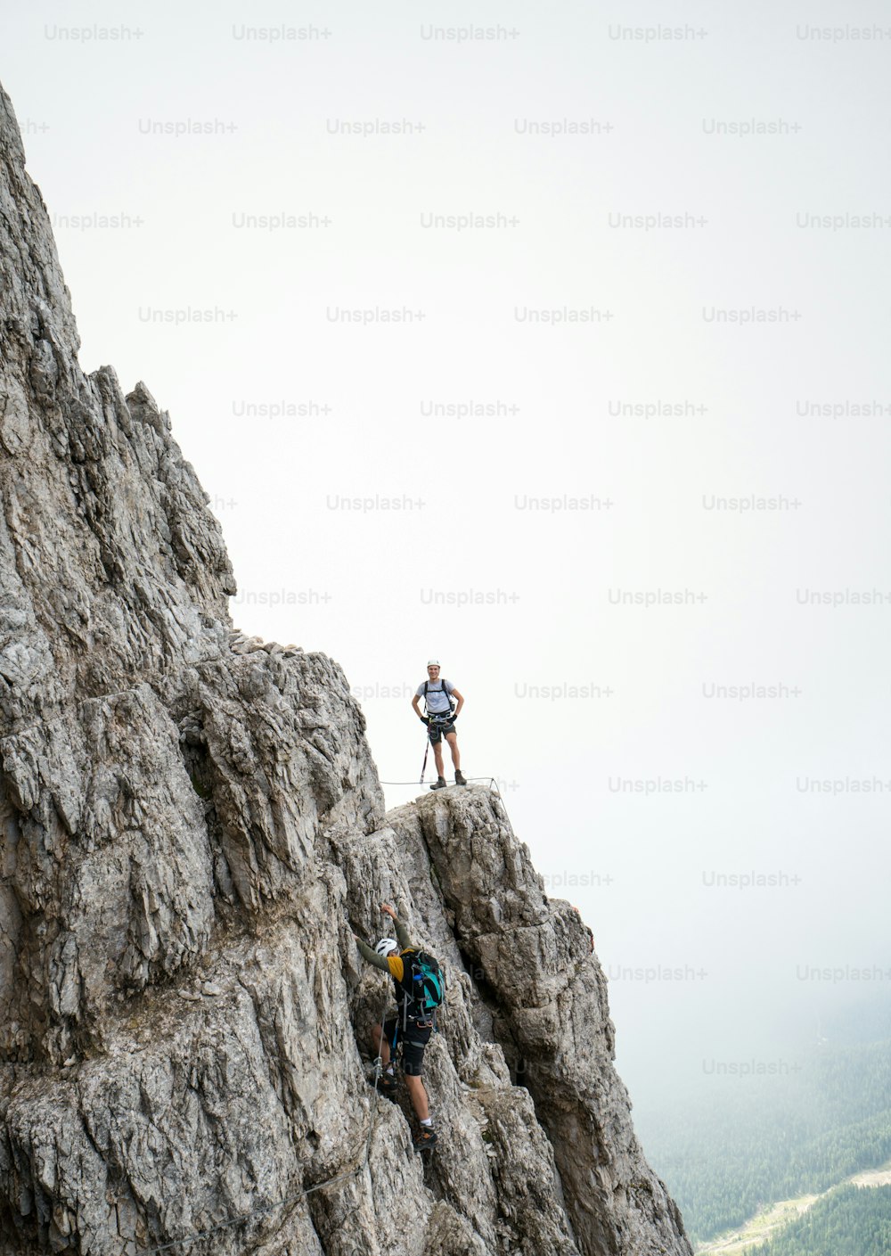 two young attractive male mountain climbers on very exposed Via Ferrata in Alta Badia in the Italian Dolomites