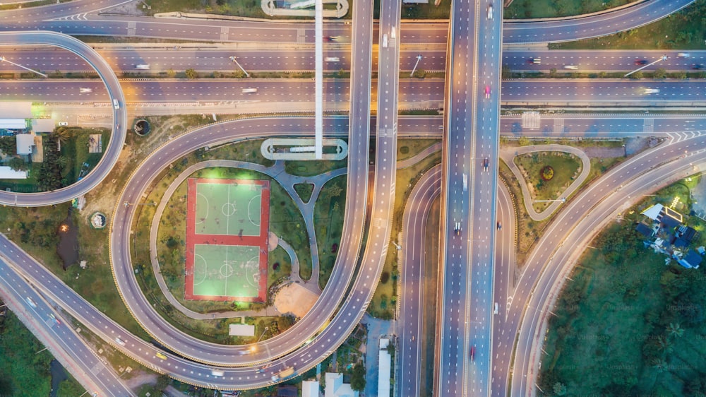 Vista aérea da rodovia cruzamento rodoviário e círculo ao entardecer para transporte, distribuição ou fundo de tráfego.