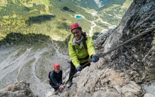 due giovani attraenti alpiniste nelle Dolomiti d'Italia con una splendida vista sul Sassolungo e sul Passo Sella