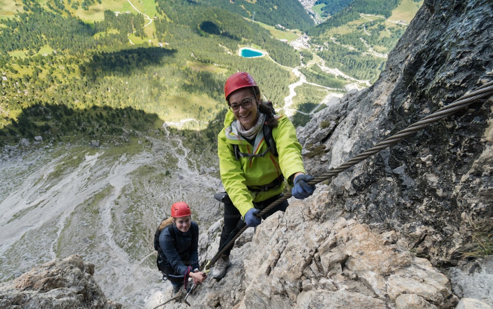 two young attractive female mountain climber in the Dolomites of italy with a great view of the Langkofel and Passo Sella