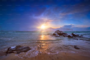 Praia do mar norueguês na costa rochosa no fiorde ao pôr do sol. Praia de Skagsanden, Ilhas Lofoten, Noruega