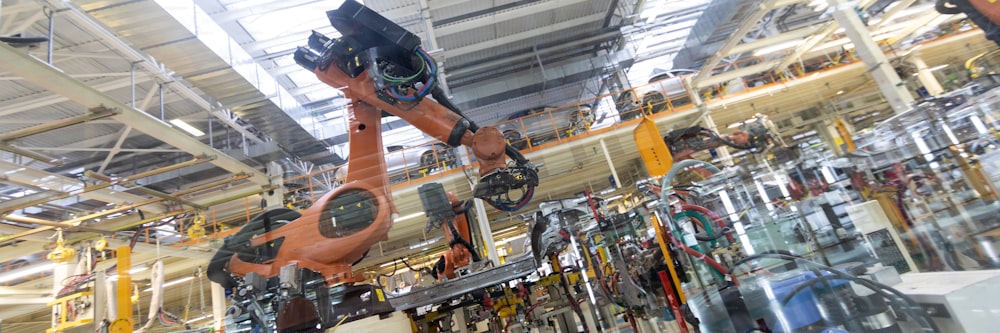 L'attrezzatura robotica raccoglie le auto sulla linea di produzione. Riprese di lungo formato nel settore automobilistico. Striscione della fabbrica di automobili