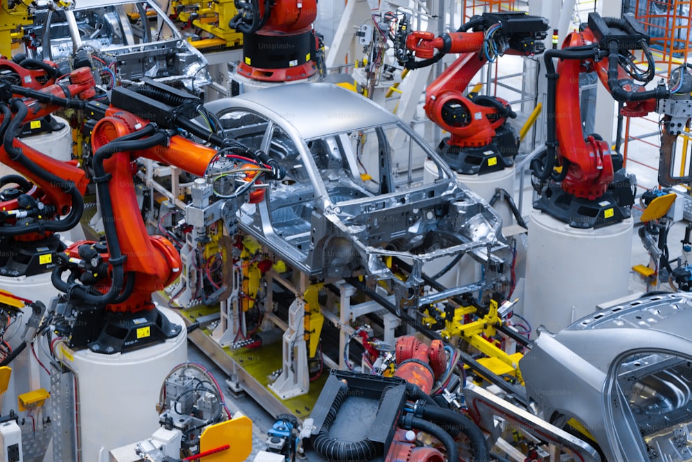 Fließbandproduktion von Neuwagen. Automatisiertes Schweißen der Karosserie in der Produktionslinie. Roboterarm an der Autoproduktionslinie funktioniert