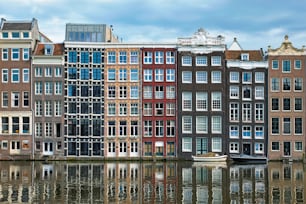 アムステルダムの運河ダム�ラックに浮かぶ典型的な家々とボートの列。アムステルダム、オランダ