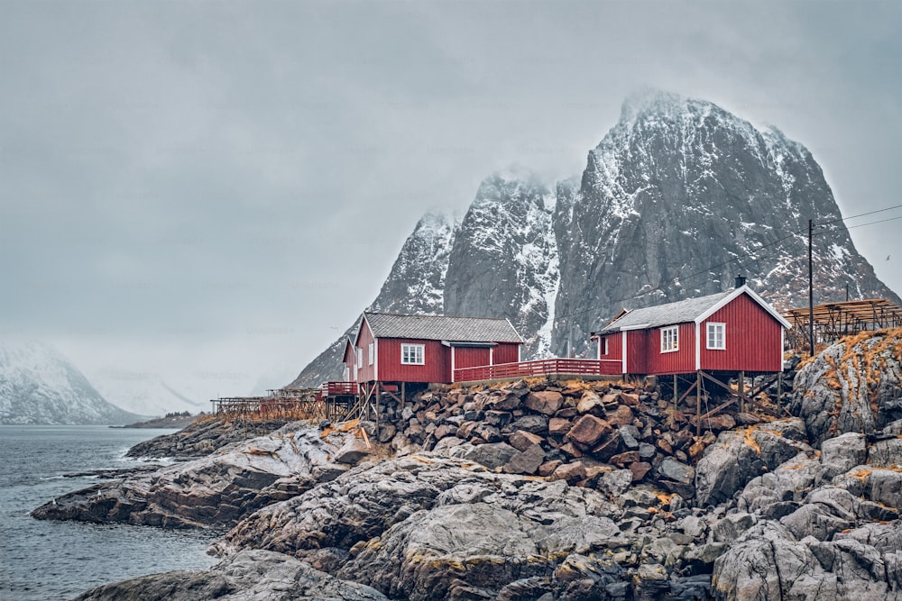 노르웨이 로포텐 제도의 유명한 관광 명소 함노이 어촌 마을에는 빨간 로르부 주택이 있습니다. 겨울에 눈이 내리는 경우