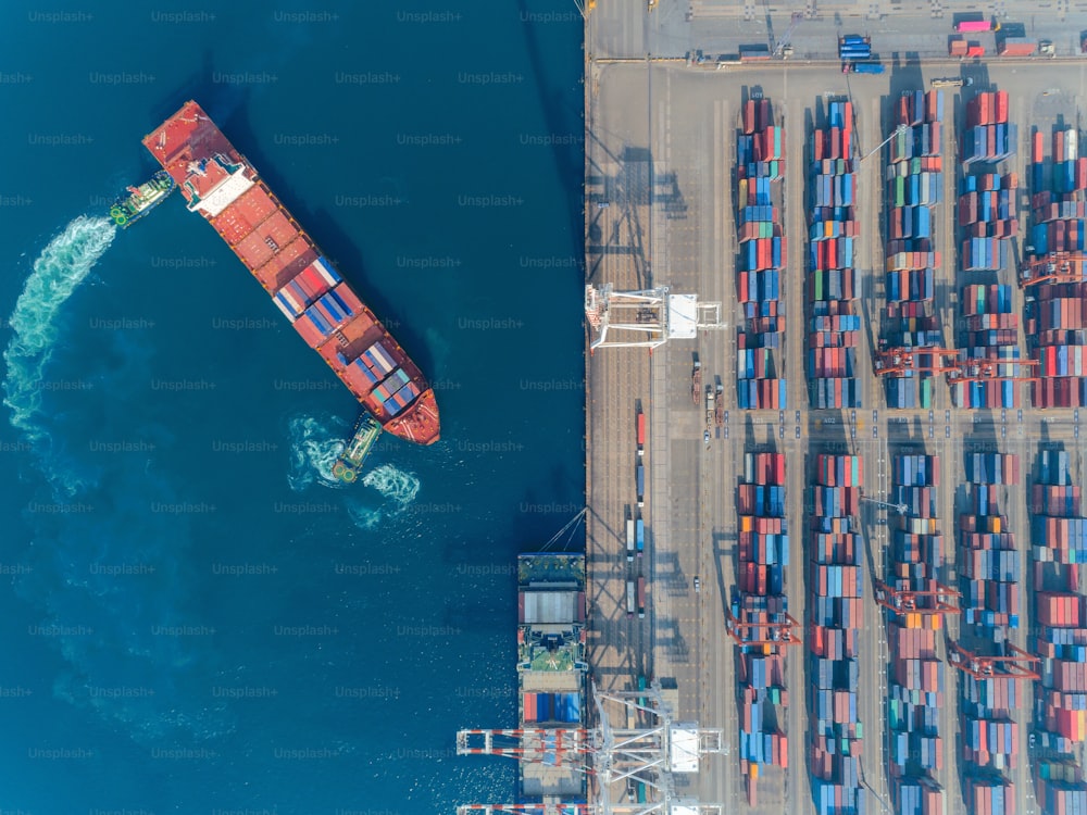 Aerial top view container ship at sea port and working crane bridge loading container for import export, shipping or transportation.