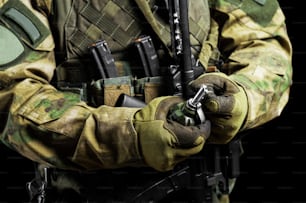 Un soldat en pleine munition de combat tire un chèque d’une grenade. Mixte