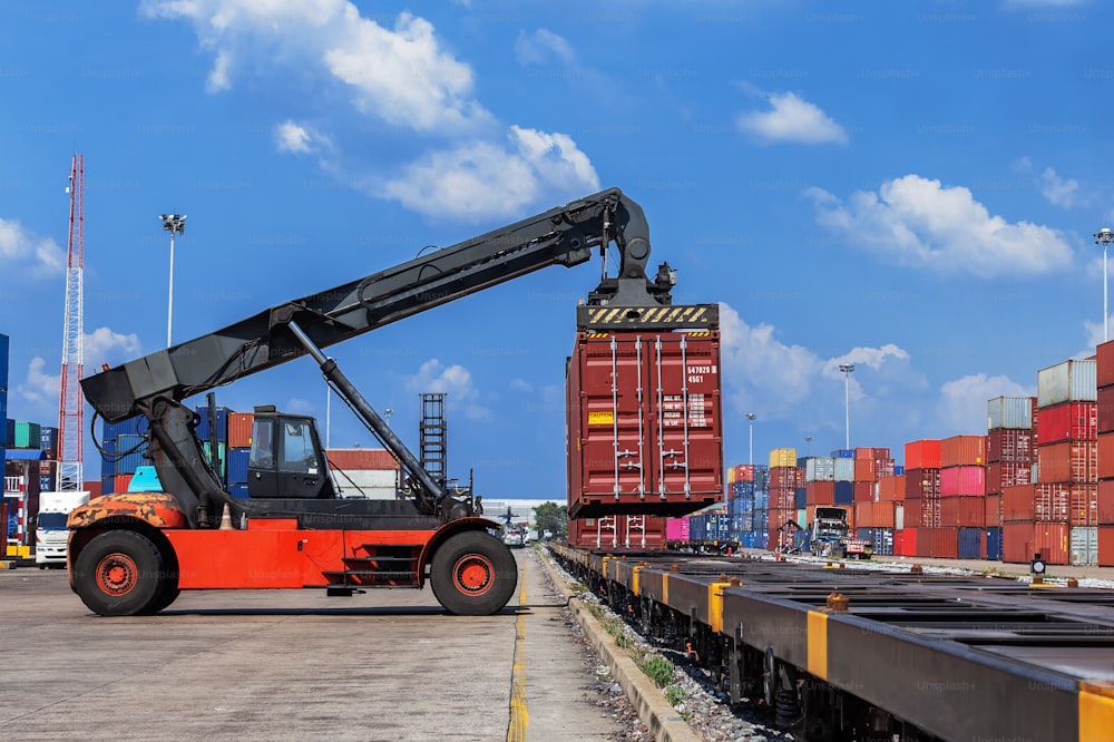 Gabelstapler, der im Containerlager arbeitet und Container lädt, um mit schönem Himmel für den Logistikversand, Importexport oder Transport zu trainieren.