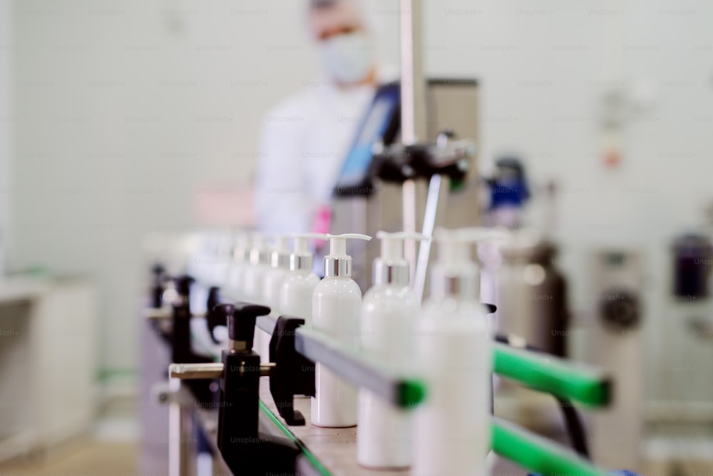 Picture of lotion bottles on production line. Bottles of cosmetic products in factory production line.
