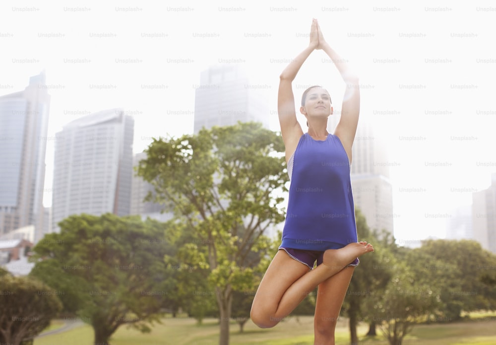 Eine Frau, die eine Yoga-Pose in einem Park macht