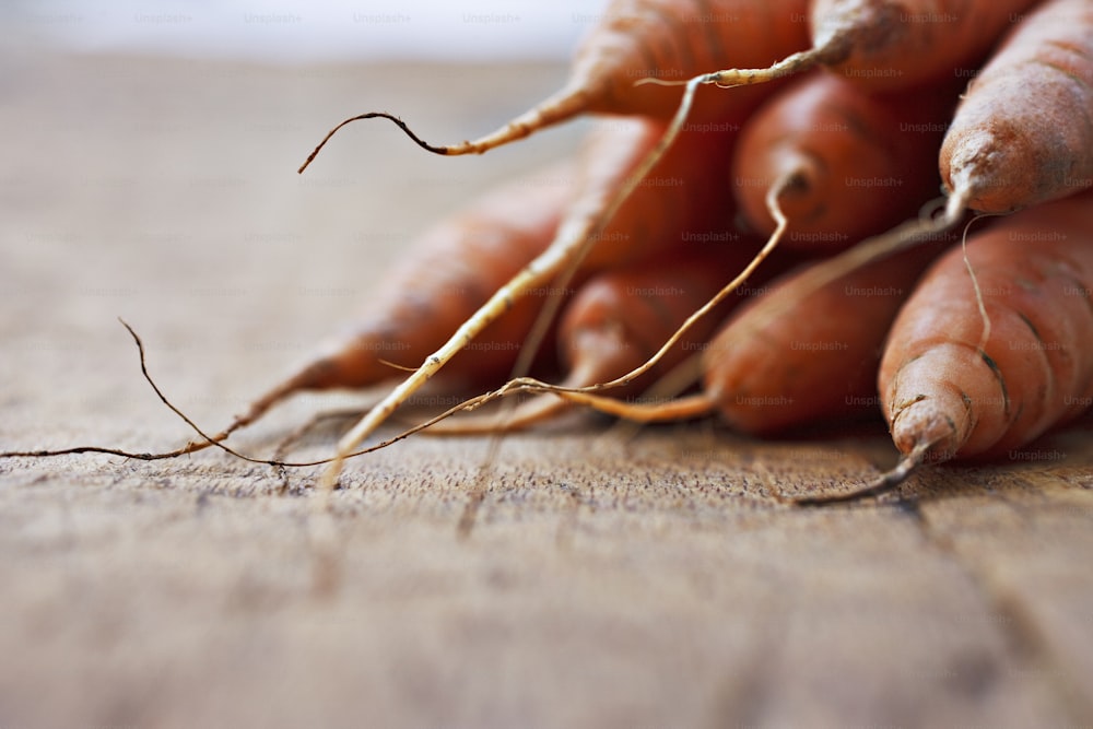 a bunch of carrots laying on top of a wooden table