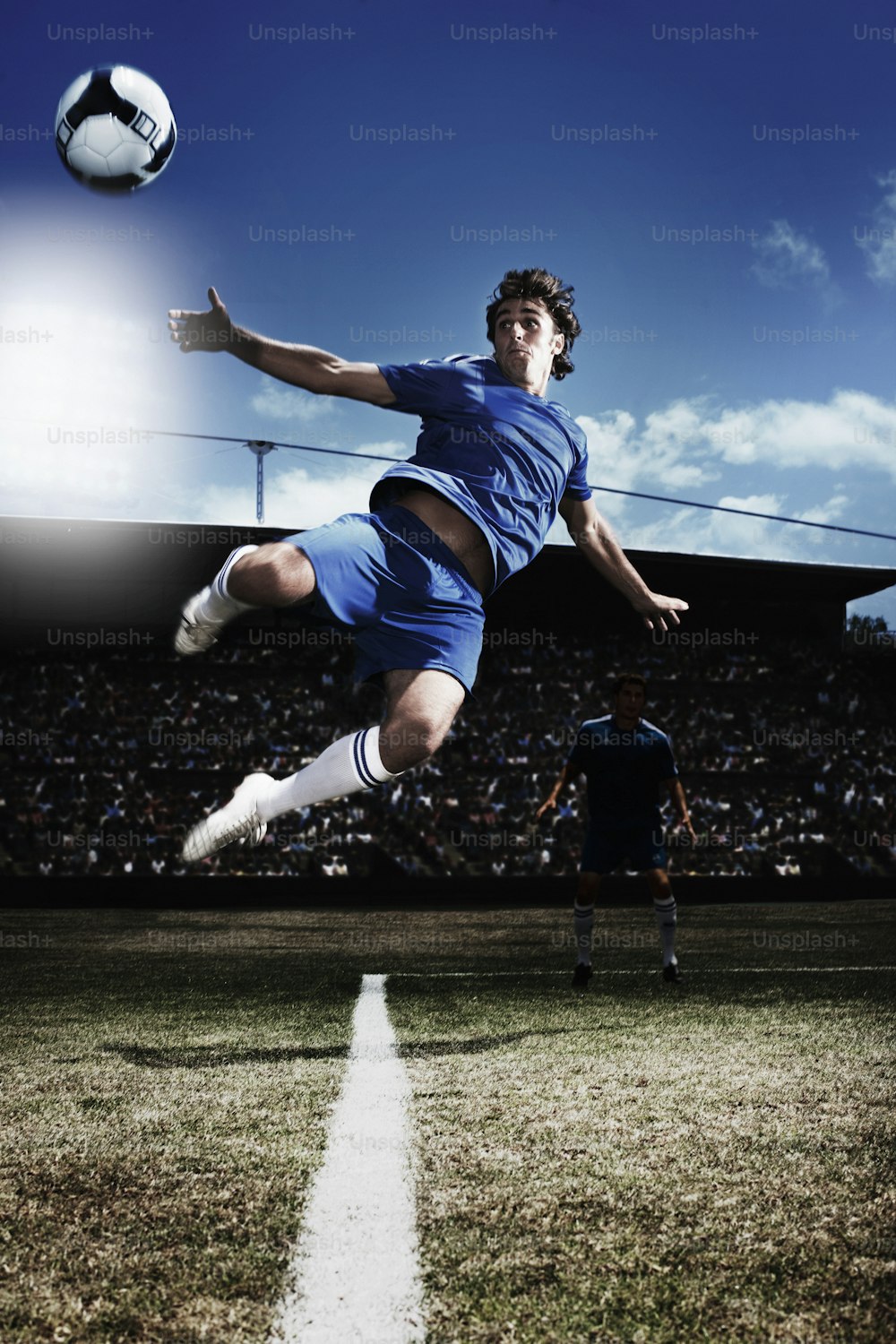 a man kicking a soccer ball on top of a field