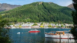 Queenstown lakefront city center shot at Lake Wakapitu, the famous lake of Queenstown, center of tourism, water sport and boat tours, South Island of New Zealand.