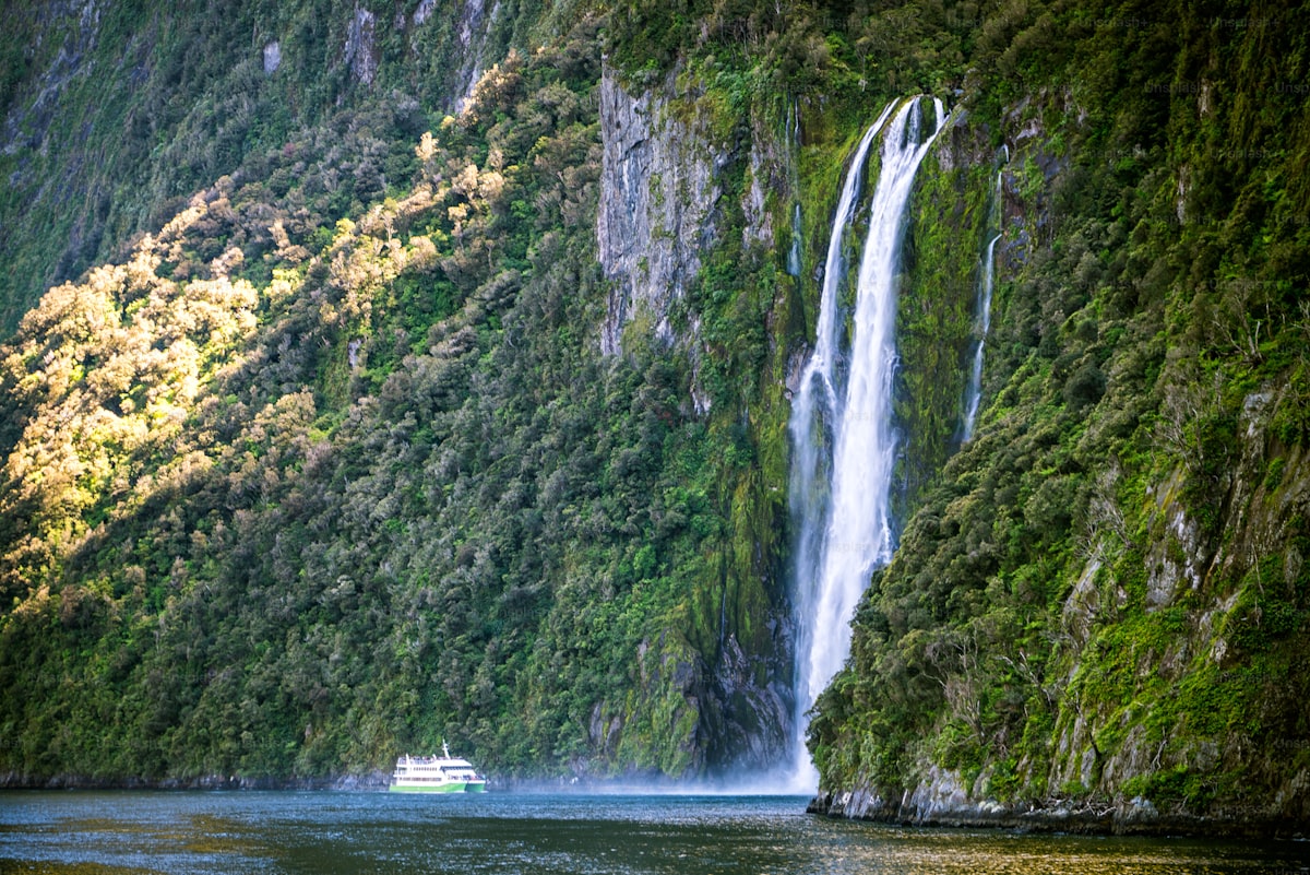 The Southern Alps - A tour boat beneath Stirling Falls in Milford Sound